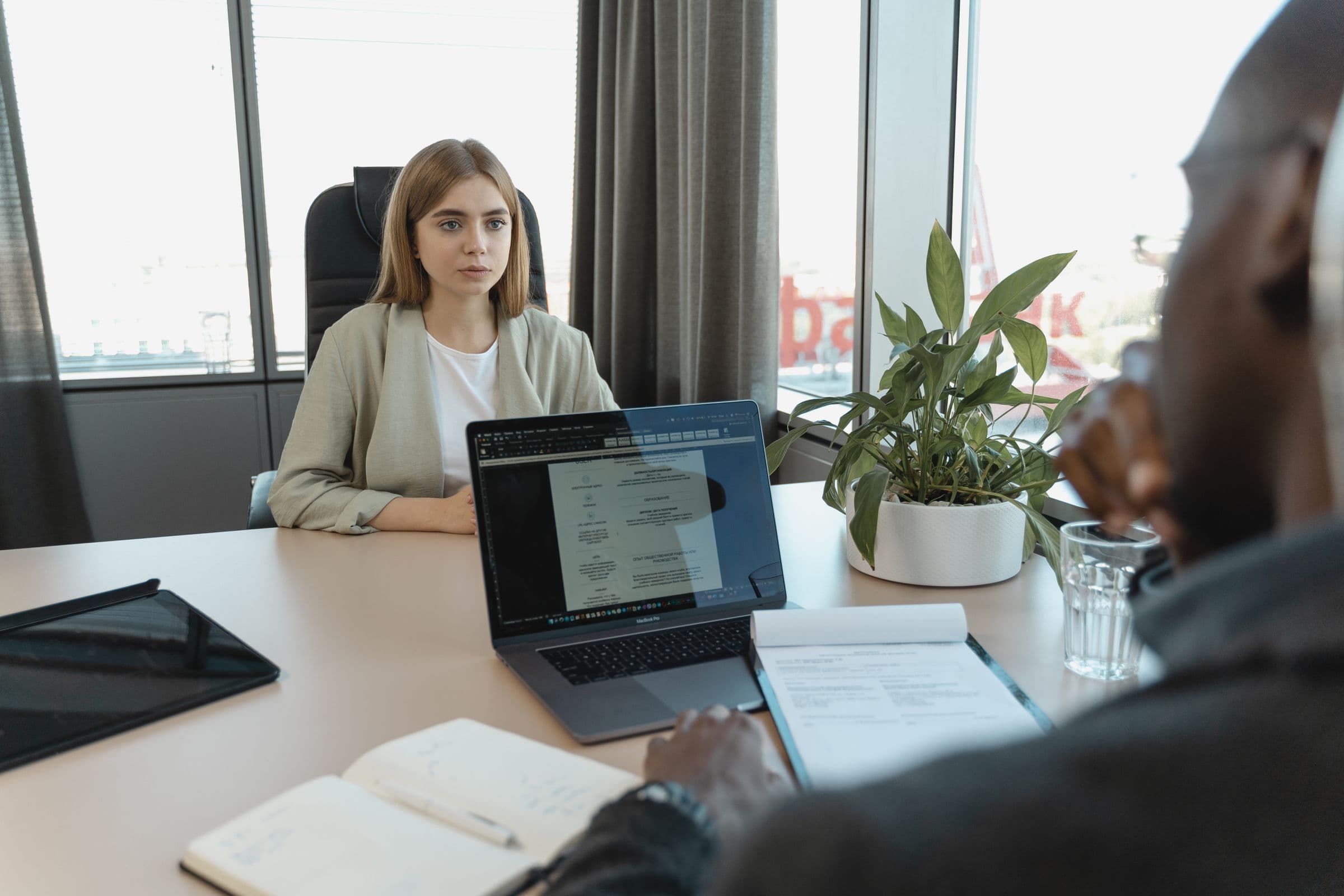 Hiring conversation across a desk in a professional setting.